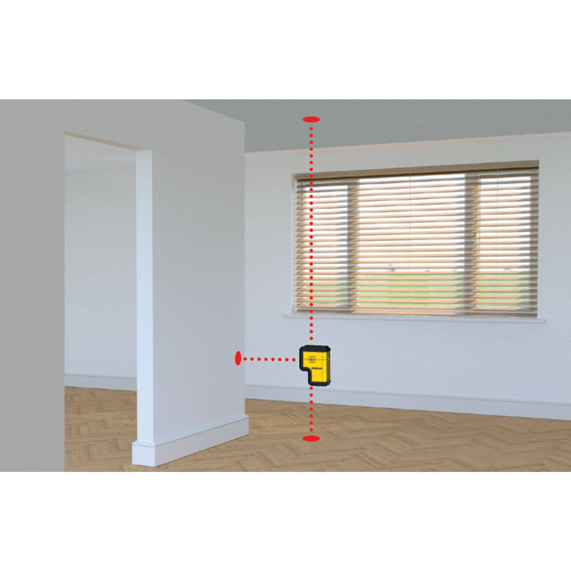 In the image, a laser distance metre is shown projecting vertically from the ceiling to the floor in a room. The walls are white.