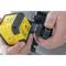 A person is holding a yellow laser level in their hands. The device is being adjusted or prepared for use.