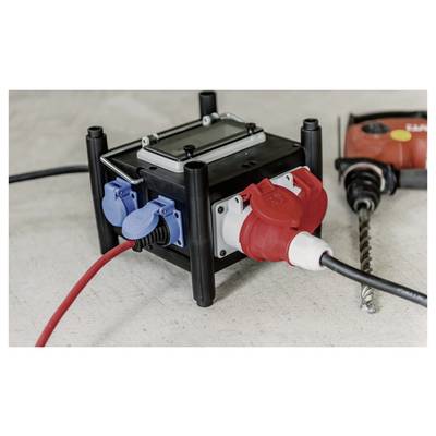 Portable electrical power distribution box with blue and red outlets and plugged-in cords on a workbench.
