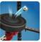 A metal ball is flying towards a black cover mounted on a red-and-black mechanism, against a blue background.