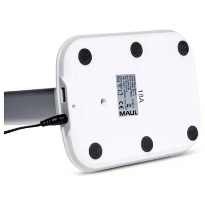 The image shows the underside of a white rectangular base of a desk lamp featuring a power cable, six black rubber feet, and a label with text.