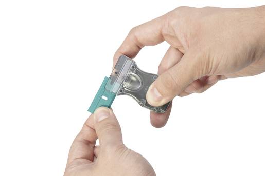 Two hands are holding a blue safety wire and a transparent plastic fuse holder for an electrical system.