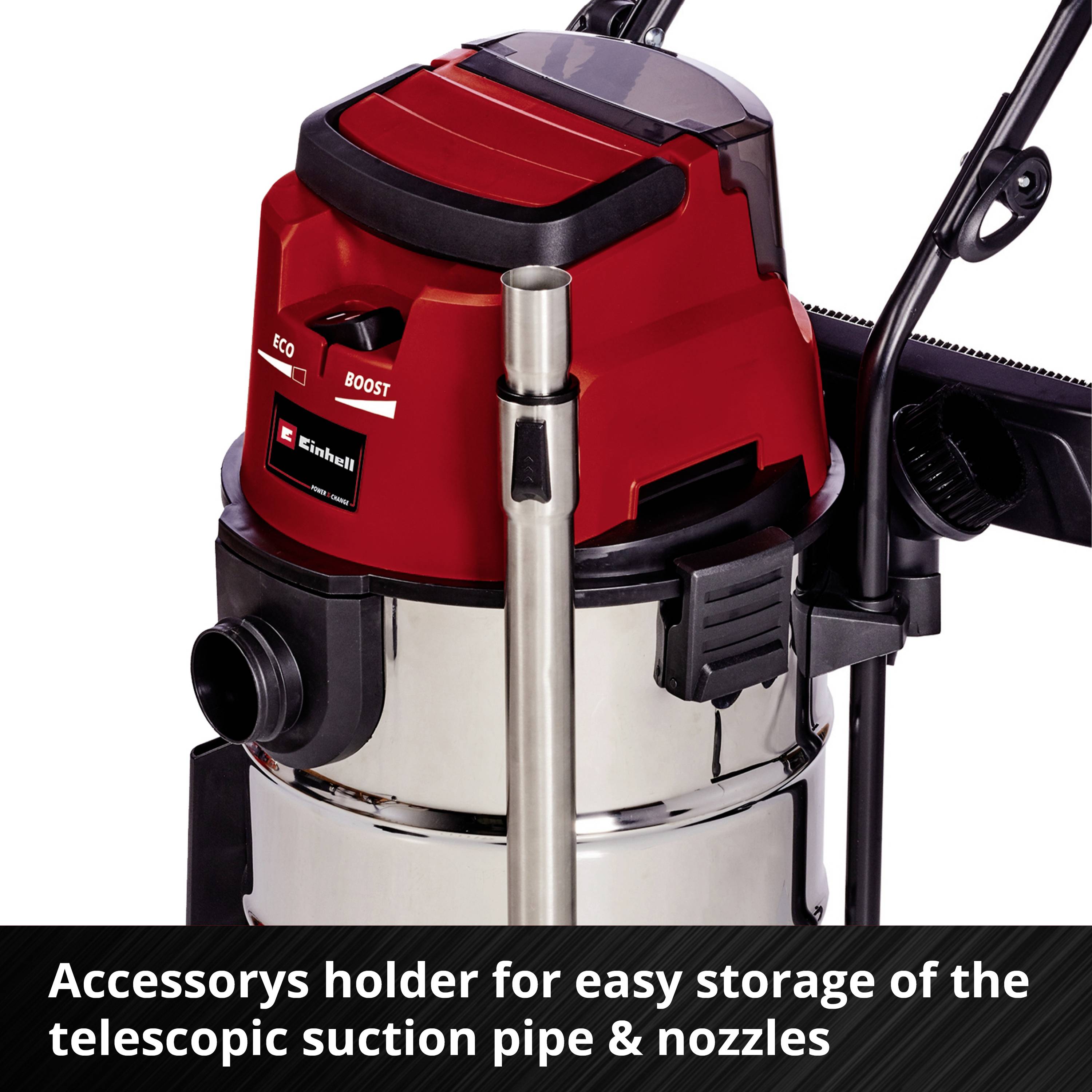 Industrial vacuum cleaner with a red housing and accessory holder for storing the telescopic suction tube and nozzles.