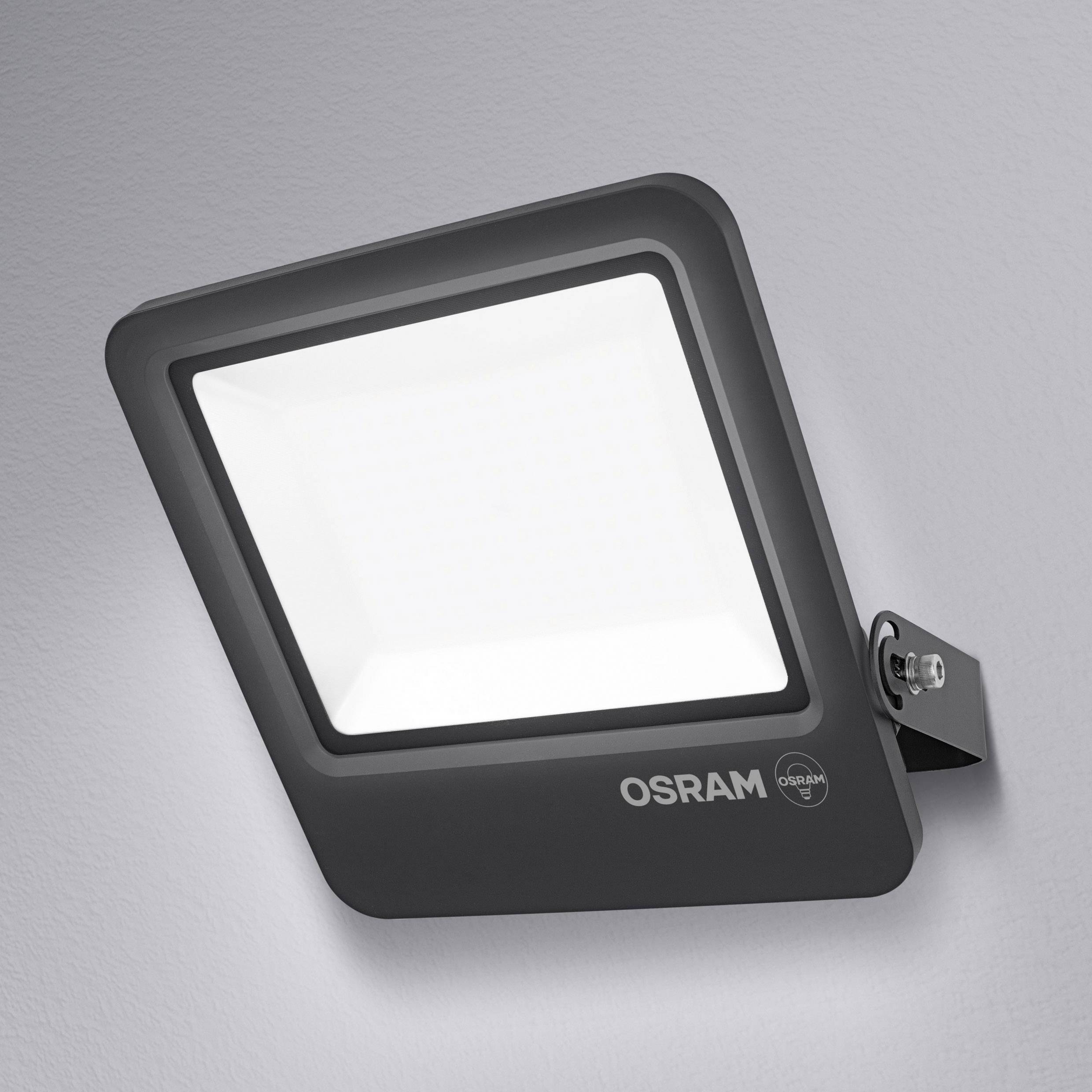 LED wall light, square, black, Osram brand, mounted on a wall. Illuminating white area.