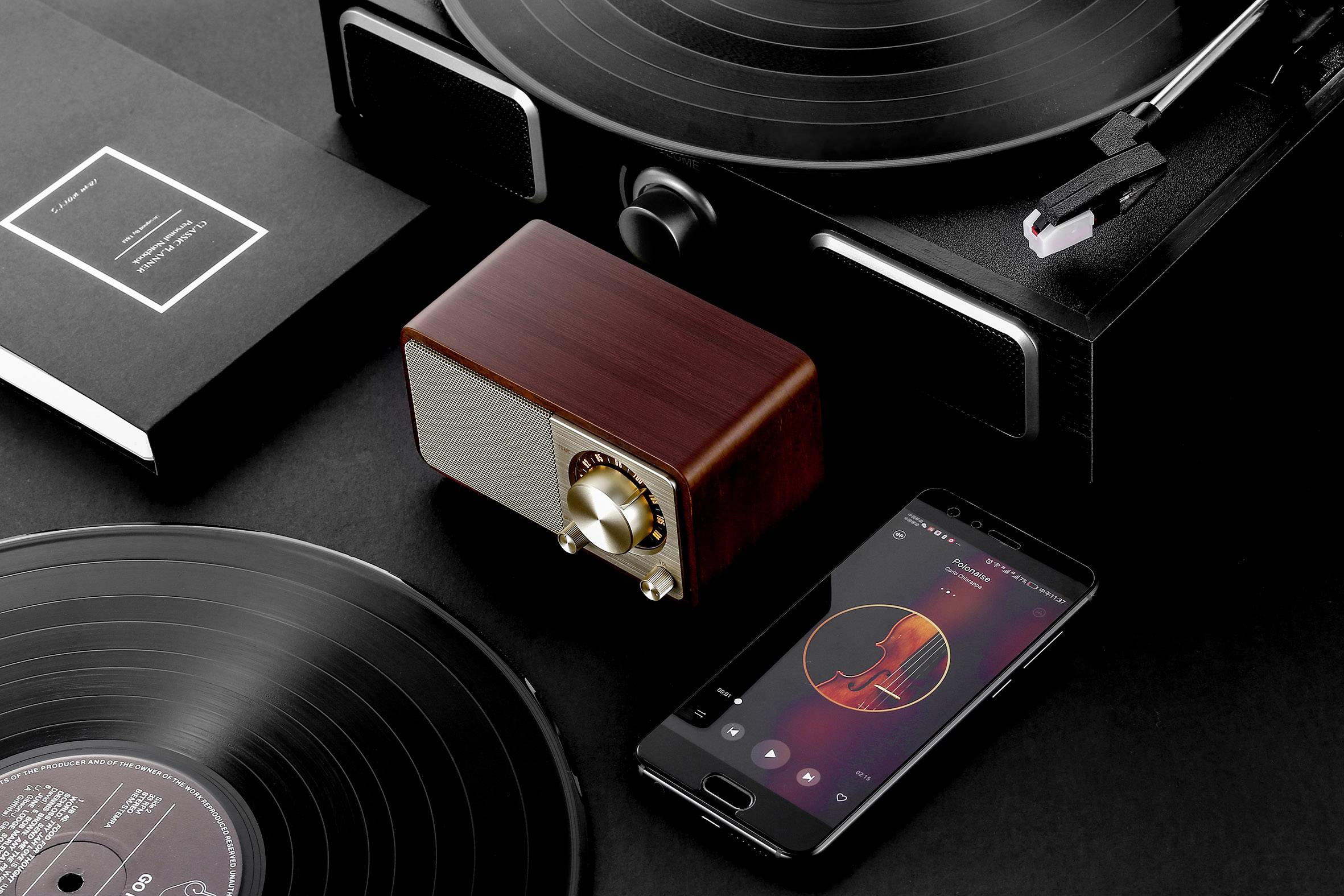 Black vinyl records, a wooden speaker, and a smartphone showcase music in an elegant black and white setup.