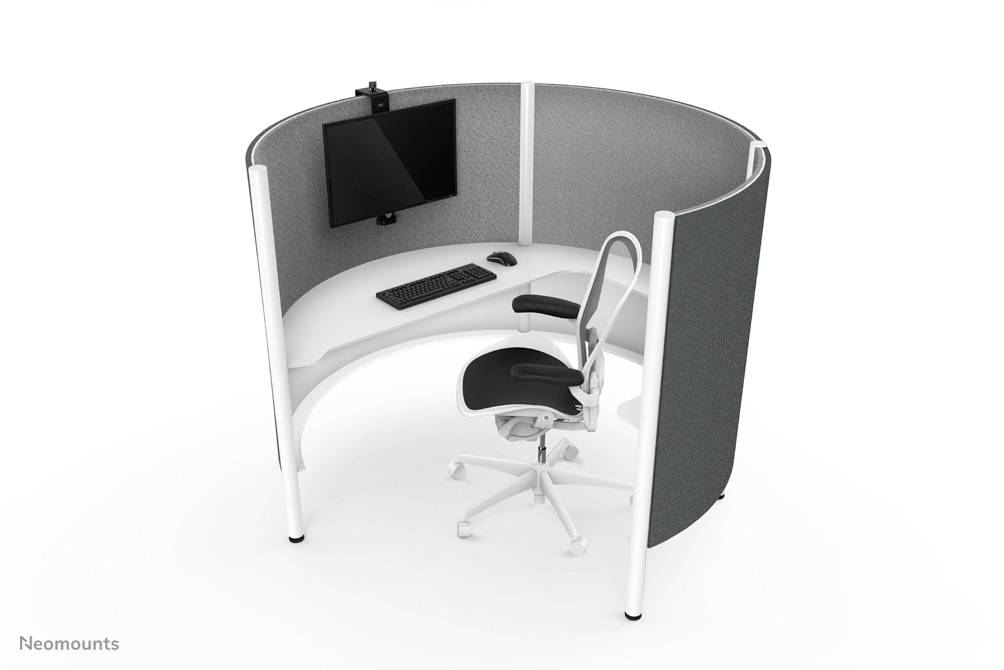 An oval workspace with curved walls, a desk with a screen and keyboard, and a swivel chair.