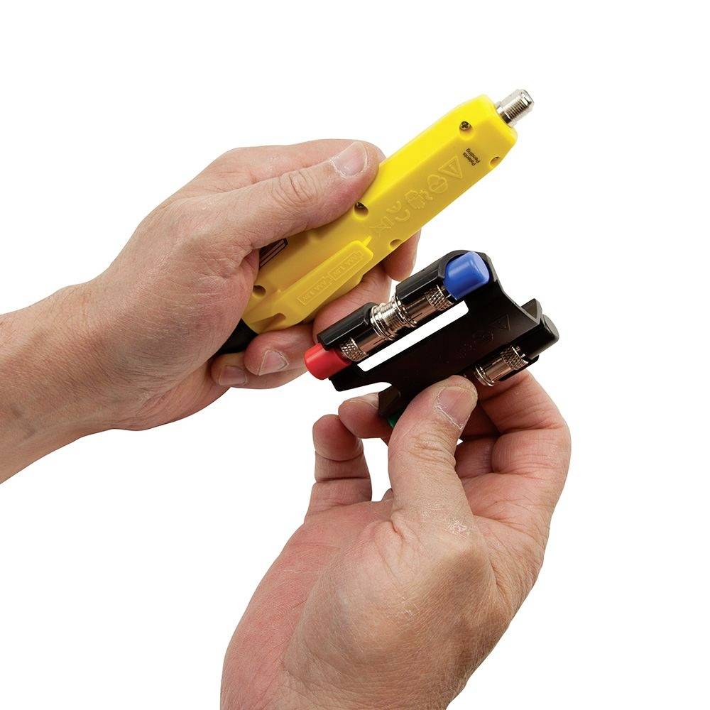 Two hands are holding a yellow and black electrical testing device.