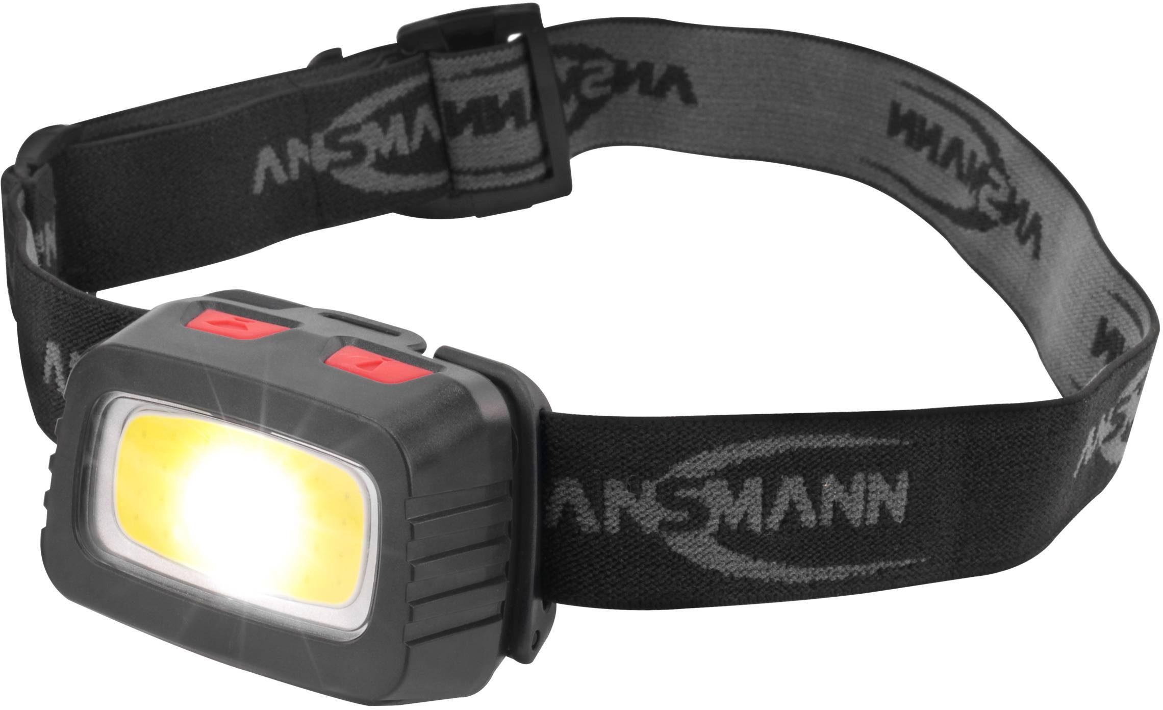 A black head torch with a bright yellow light at the front and an adjustable strap marked 'ANSMANN'.