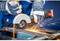 'A person in blue protective clothing is cutting metal with an angle grinder, generating sparks.'