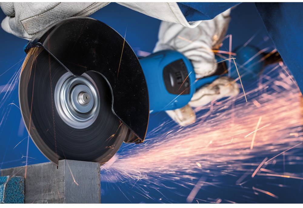 A person is cutting metal with a blue electric cutting disc, with sparks flying. Safety equipment such as gloves is visible.