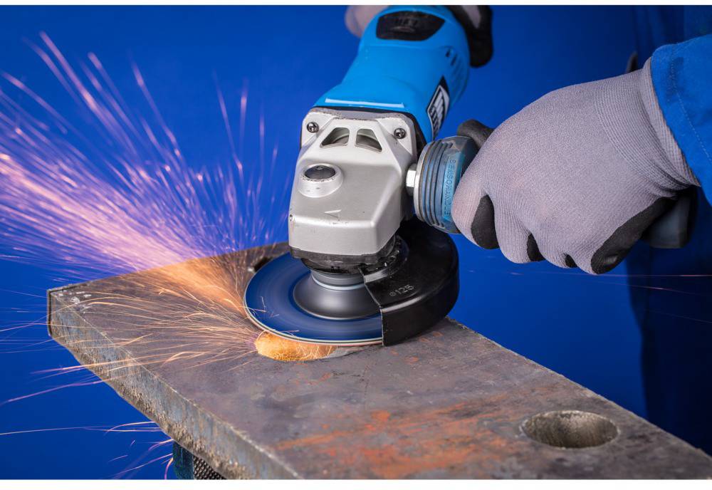 A person is grinding metal with an angle grinder, with sparks flying.