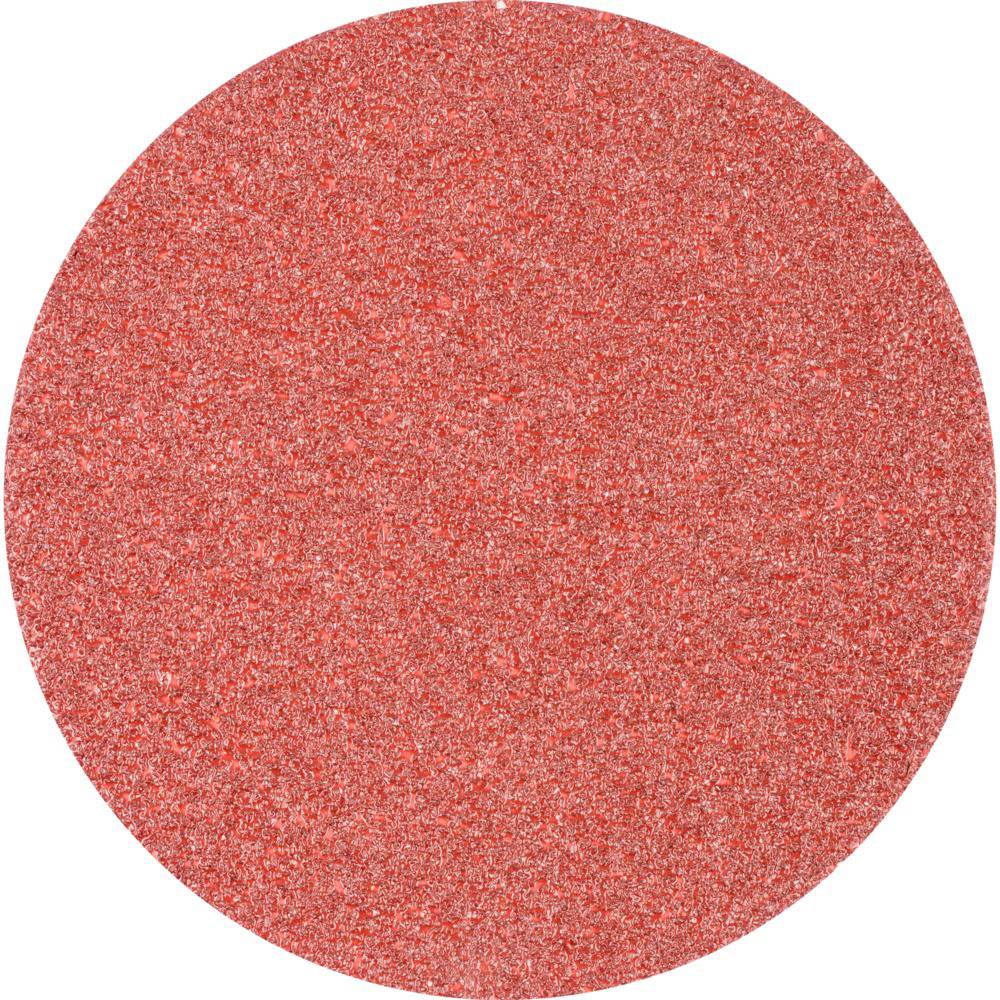 Round red sheet of sandpaper. Surface structure shows sand grains.