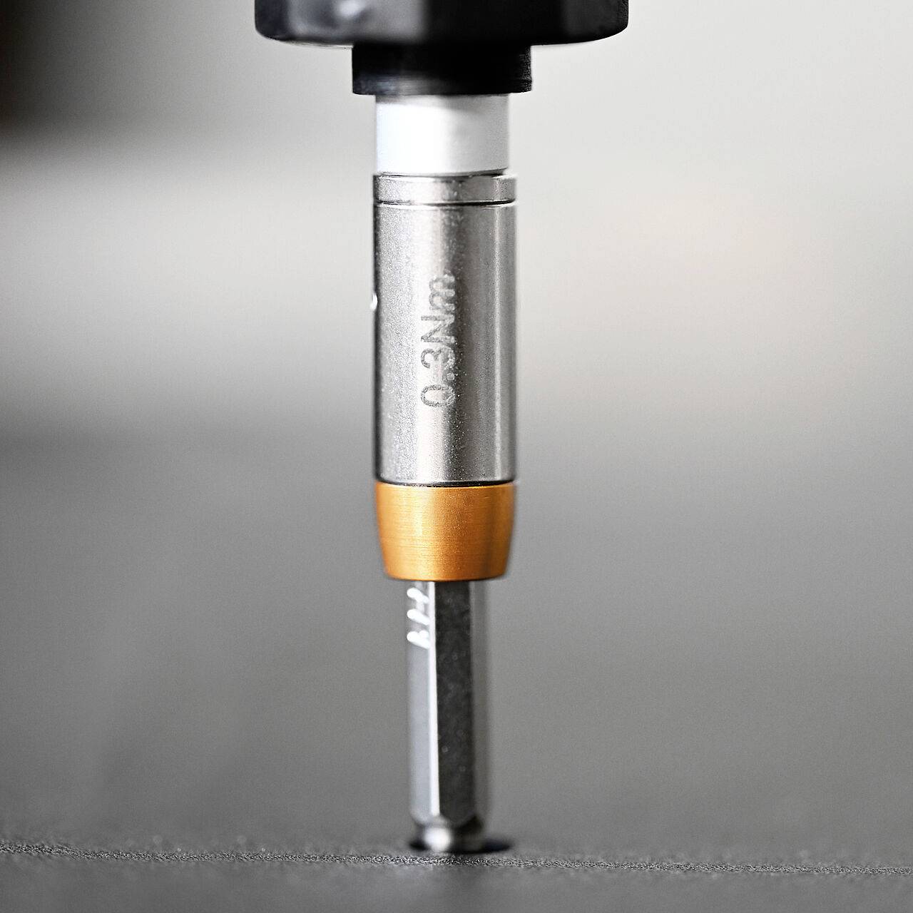 A close-up of a screwdriver bit attached to an electric tool, ready for use.