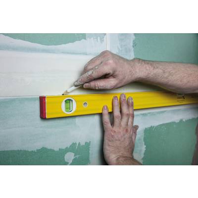 A person is checking the alignment of a wall with a spirit level during renovation work.