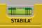 Spirit level with a yellow housing and green vial, indicating a horizontal alignment.