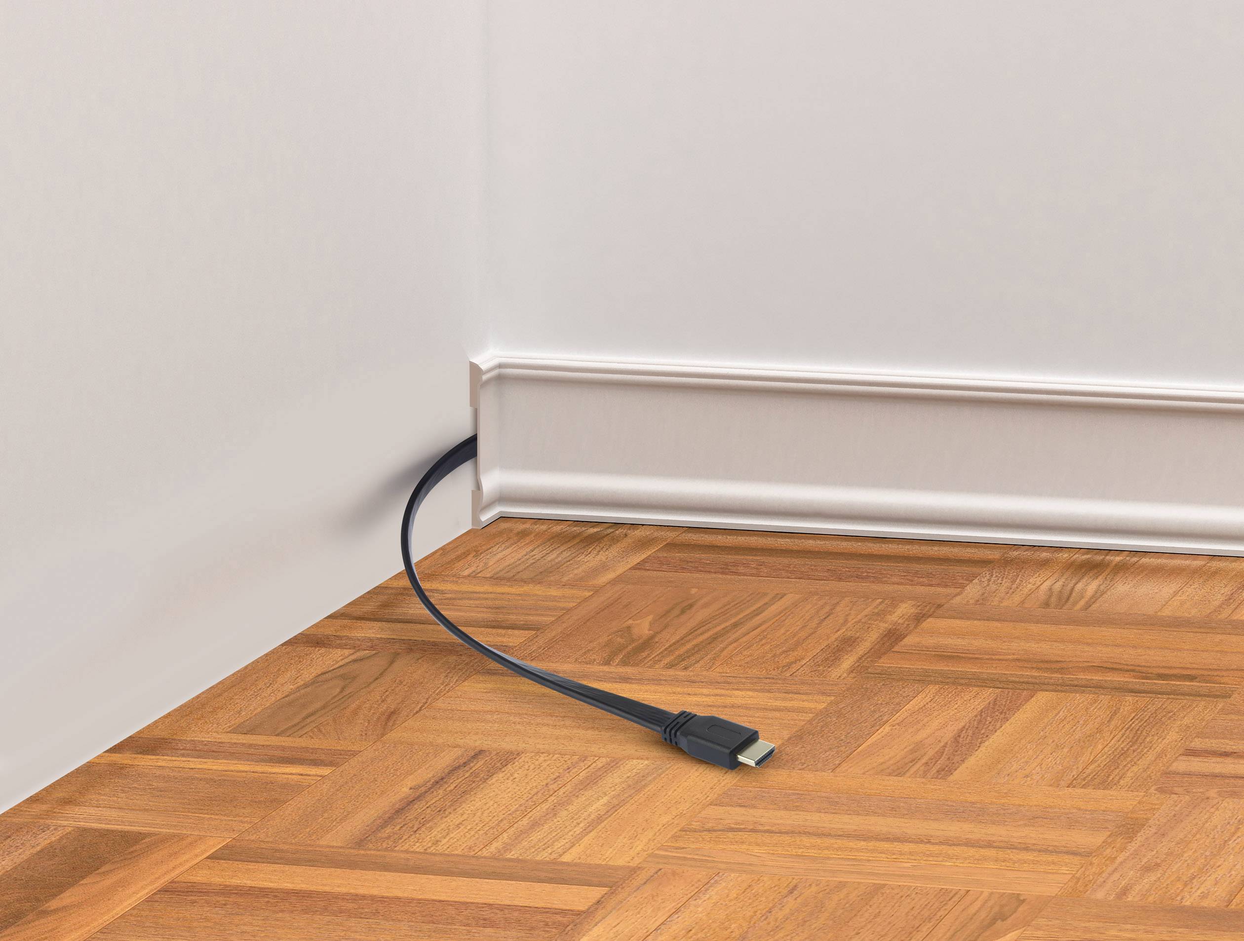 A single black HDMI cable protrudes from the wall with a white skirting board and rests on a parquet floor.