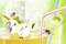 Wasps are flying around a glass of orange juice and straws. Two circular inserts show devices designed to deter wasps.