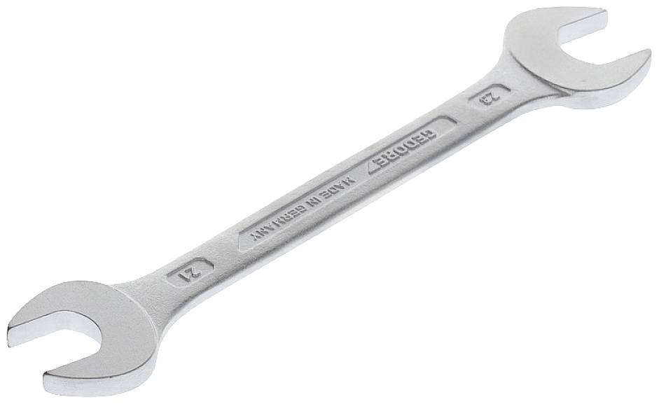A silver double-ended spanner with different sizes at each end is lying on a white surface.