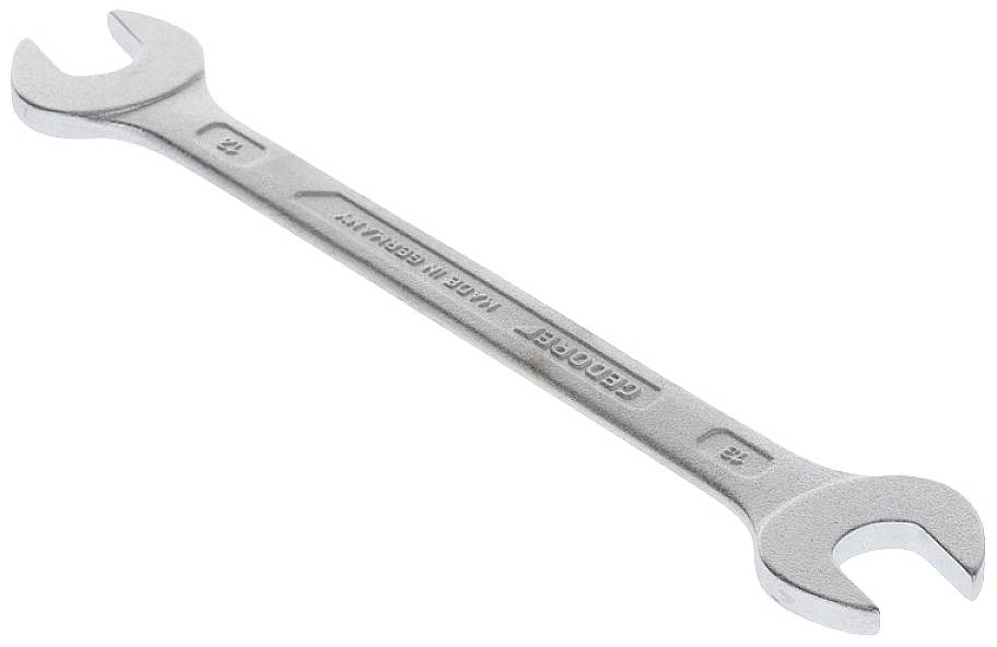 A silver double-ended spanner lies diagonally, with two open ends for different screw sizes.