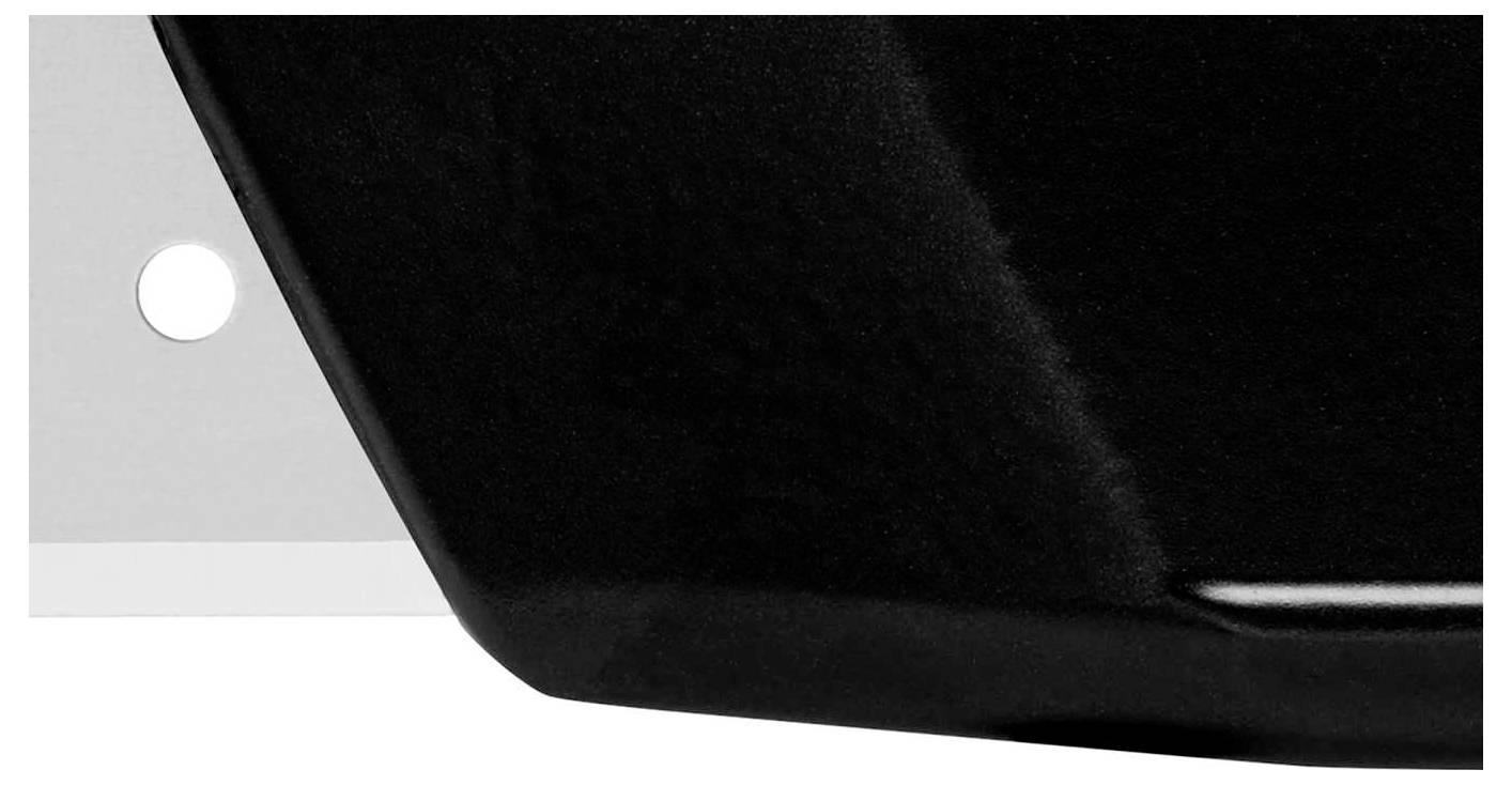 Black surface with a smooth, glossy texture, a white element with a small hole on the left.