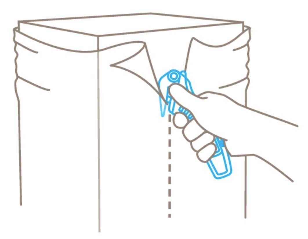 A hand is using a utility knife to open a package along a dotted line.