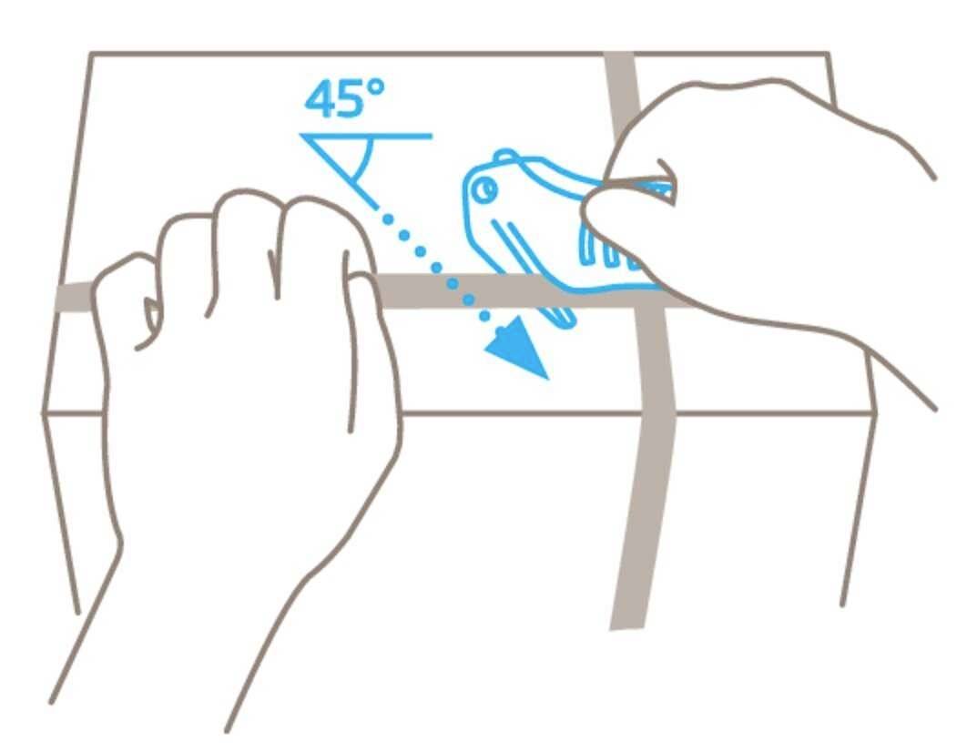 Hands are using a box cutter to open the adhesive tape on a cardboard box. The cutting angle should be 45 degrees.