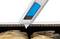 A silver cardboard knife cuts through corrugated cardboard over heat-sealed pouches.