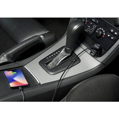 A mobile phone is being charged in the car. It is connected to the USB socket next to the gear stick via a cable.