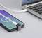A smartphone is charging next to a laptop. The charging cable is connected, and the screen displays 54% battery charge.