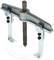 A two-armed metallic puller with a central screw designed for removing tightly fitted components from shafts or axles.