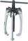 A silver puller with three gripping arms and a threaded rod in the centre, used for removing bearings or gears.