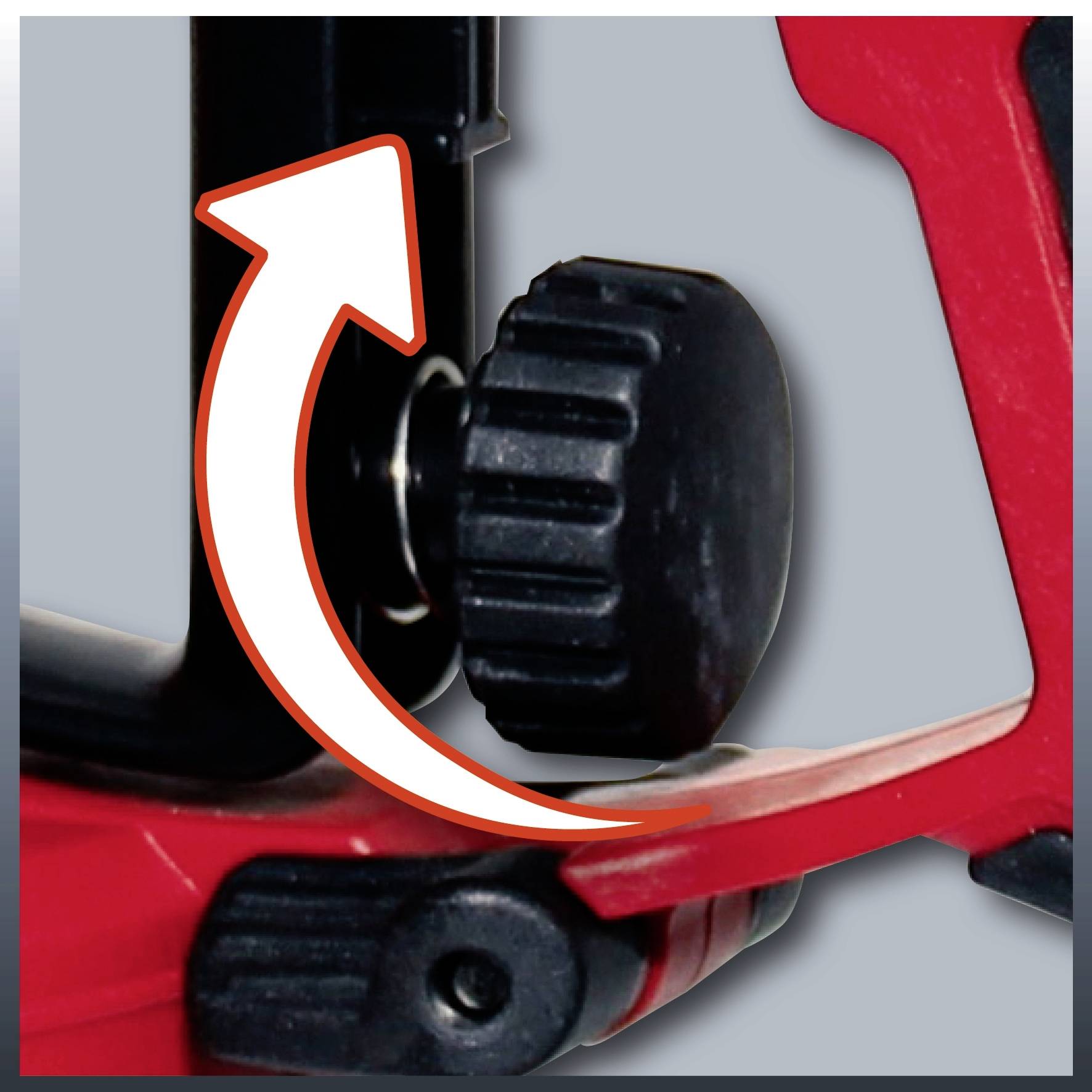 Close-up of a black rotary knob on a red device with a white arrow pointing up and to the left, illustrating the direction of rotation.