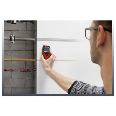 Person using a handheld level to check a horizontal line on a wall during interior construction or installation work.<br>