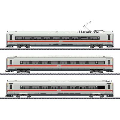 Three trains standing side by side on railway tracks, viewed from the side. Each train has two red stripes and shows different carriages.