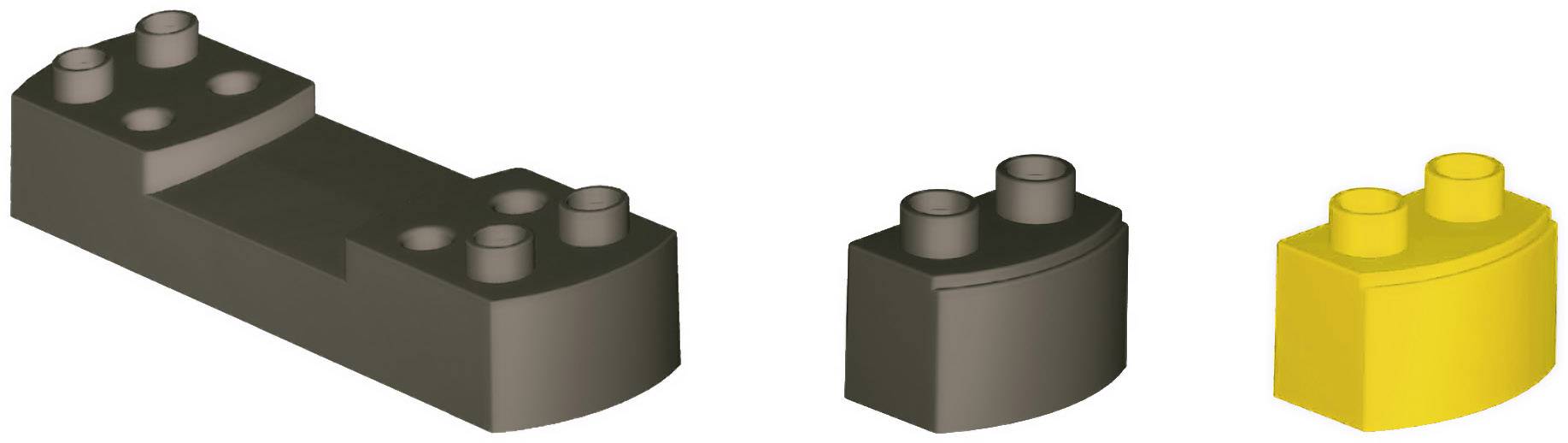 Three building blocks: a large black one, a small black one, and a small yellow one, arranged in a row side by side.