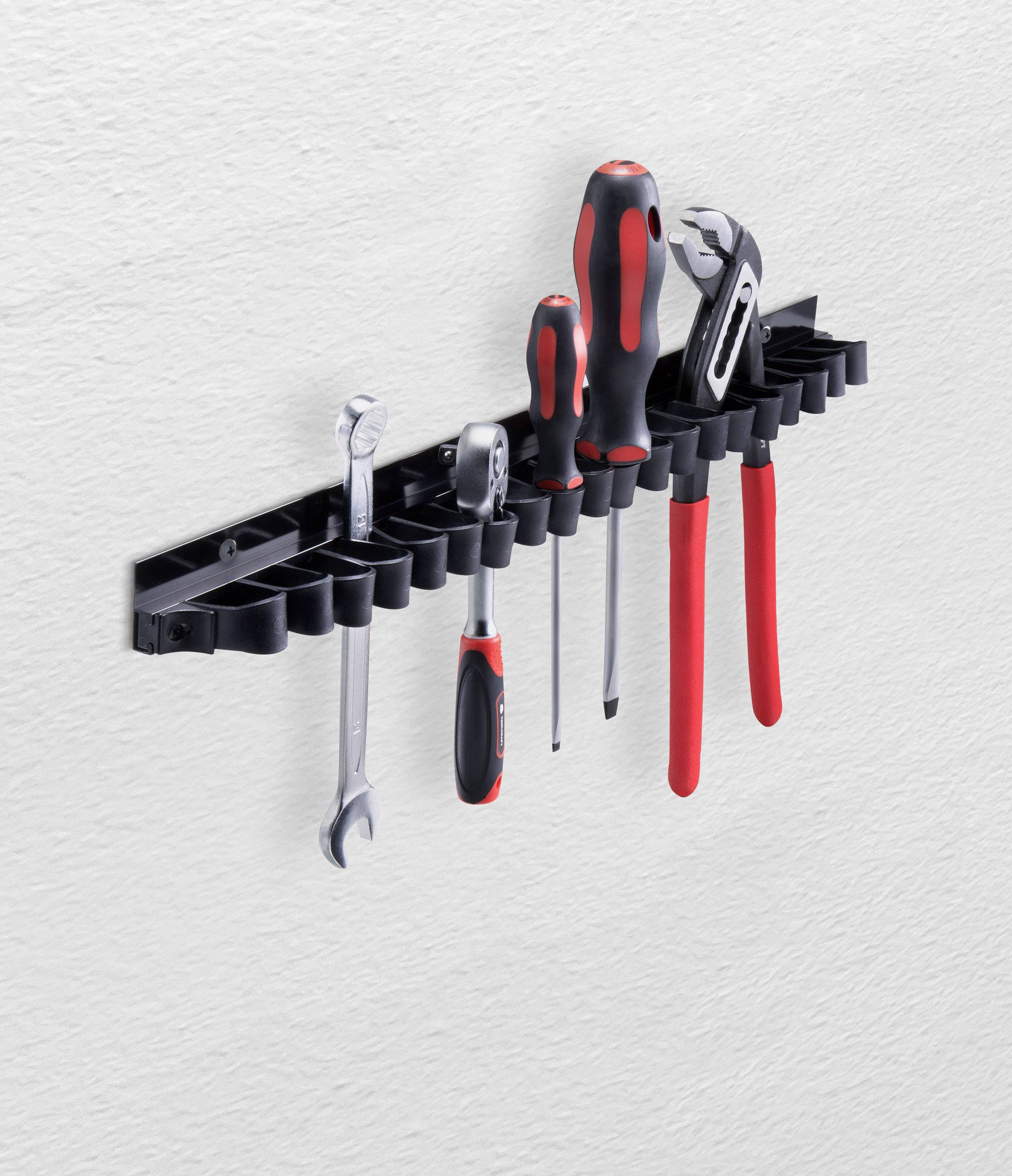 Tool holder mounted on the wall with screwdrivers, pliers and spanners, all in a black and red colour scheme.