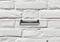 Spirit level resting on a red string against a white brick wall, indicating horizontal alignment.