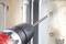 'Cordless drill secures screw in metal plate.'