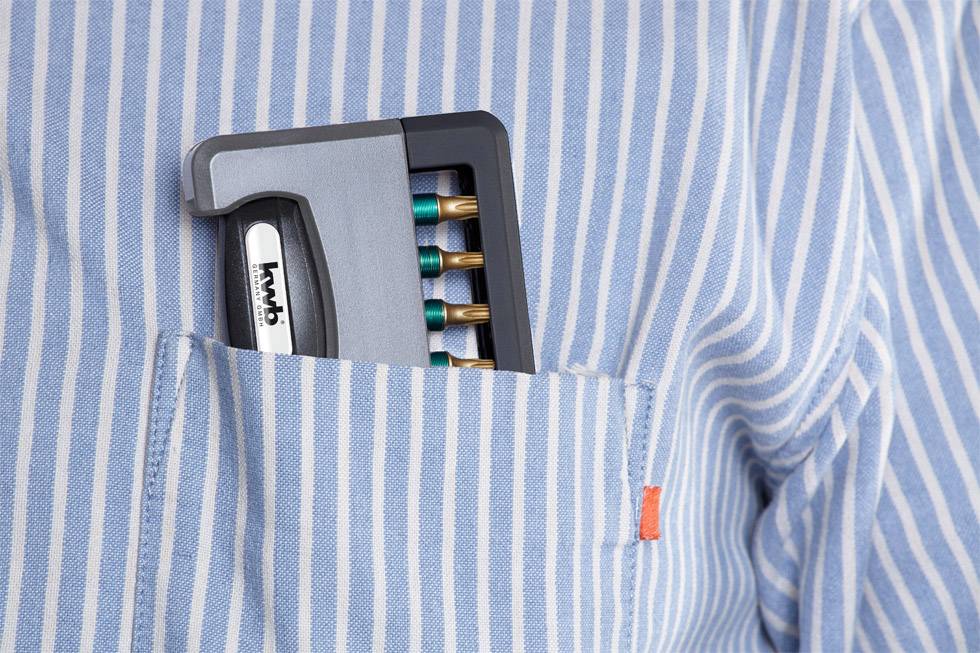 Ballpoint pen set with five pens in the breast pocket of a blue and white striped shirt.