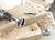 Drill with a Forstner bit drilling into wood. Wood shavings are lying on a workpiece with neatly drilled holes.