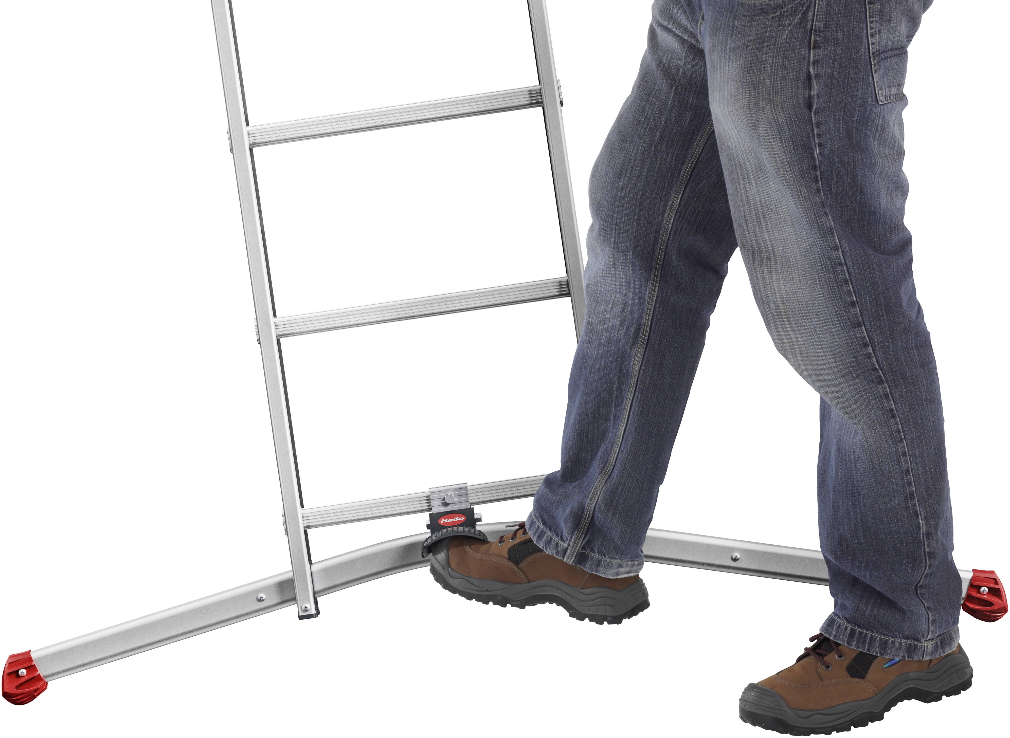 A person wearing jeans is standing on the stabilising foot of a silver ladder with red feet.