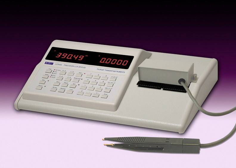 An electrical measuring instrument with a digital display and keypad, connected to a test probe. It displays numerical values.
