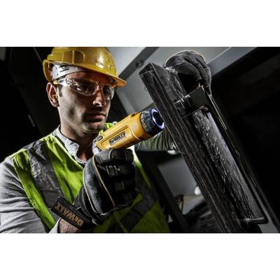 A construction worker is wearing protective clothing, using an electric drill on a metal frame. Safety and precision in focus.