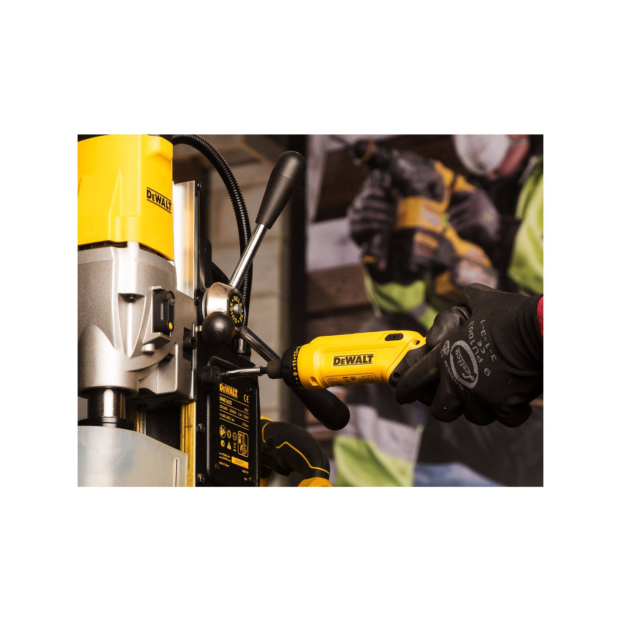 A person is working with a yellow DeWalt drill, wearing work gloves and safety clothing.