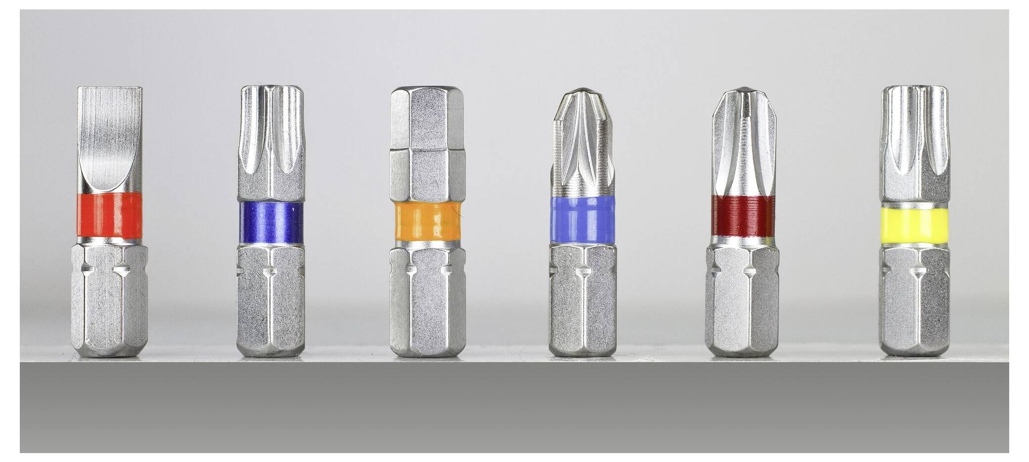 Six different screwdriver bits lined up side by side, each marked with coloured rings for identification.