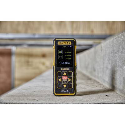 A laser distance measurer is standing on a concrete block in an unfinished room. The display shows a distance of 1.6630 metres.