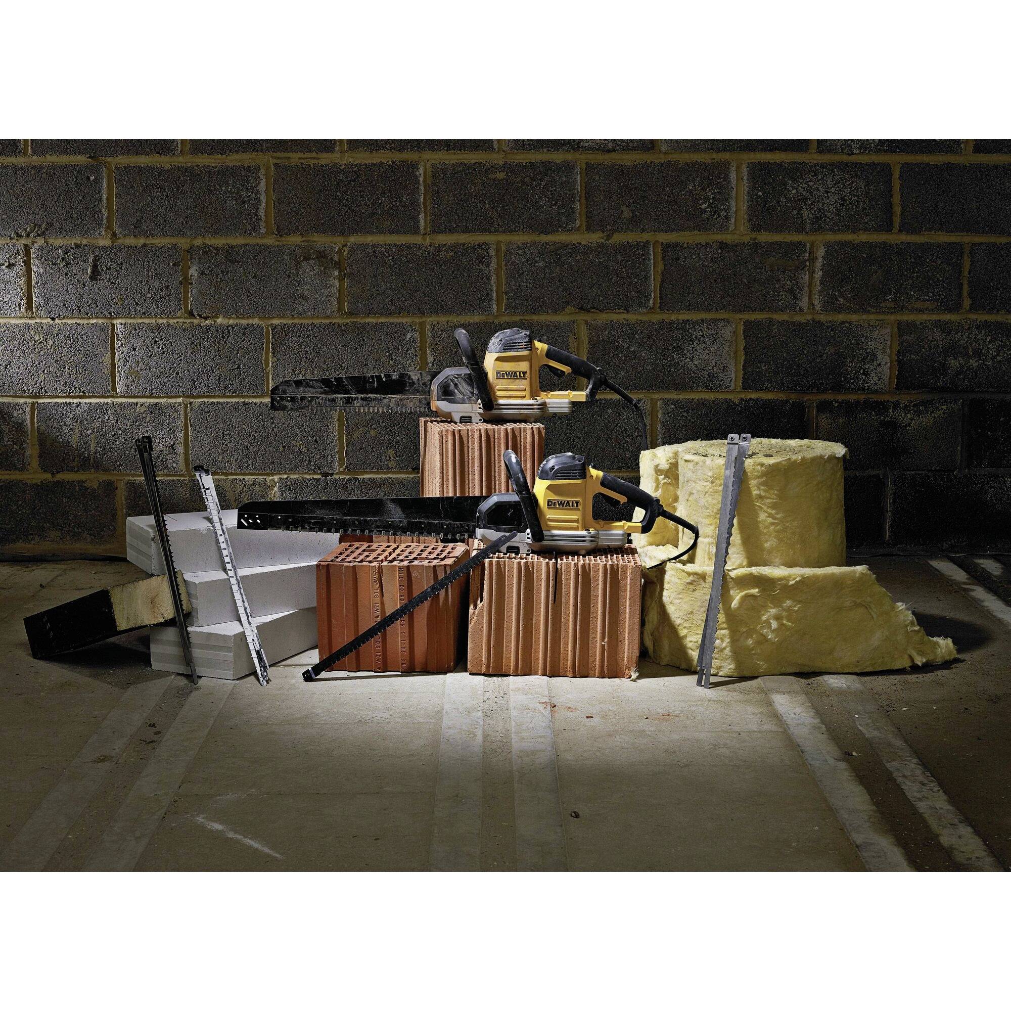 Power drill and tools on stacked building materials such as bricks, polystyrene and insulation wool in a construction site environment.