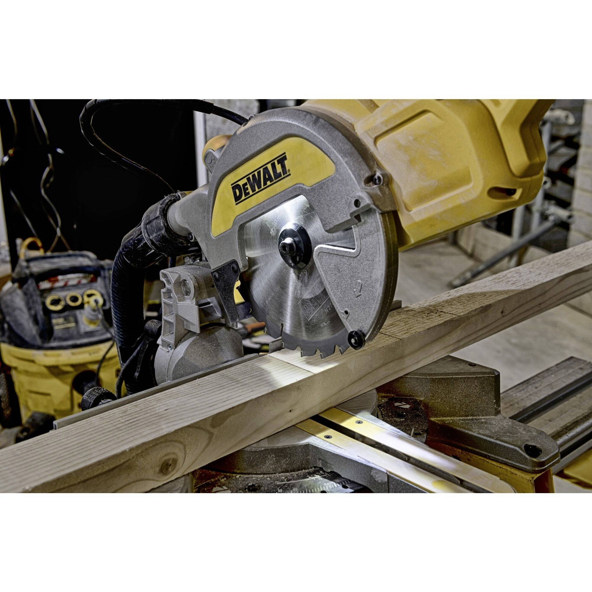 A table saw is cutting a wooden board in a workshop. The saw has a yellow casing with the inscription 'DEWALT'.