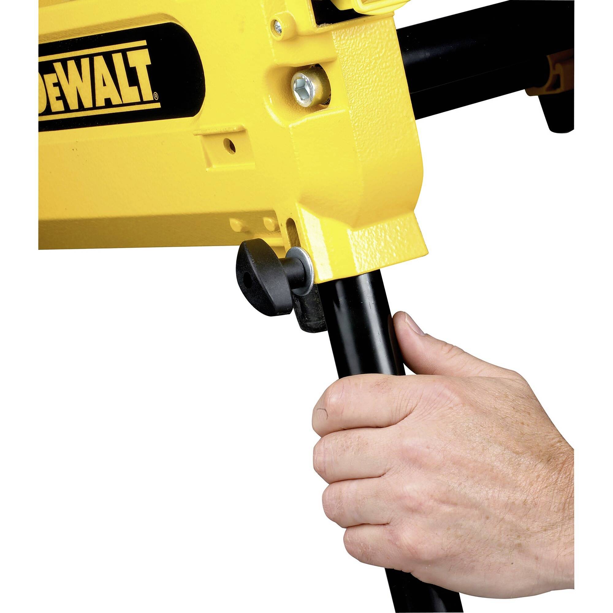A hand adjusts a yellow device with a black print. The device is mounted on a black stand.
