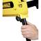 A hand adjusts a yellow device with a black print. The device is mounted on a black stand.